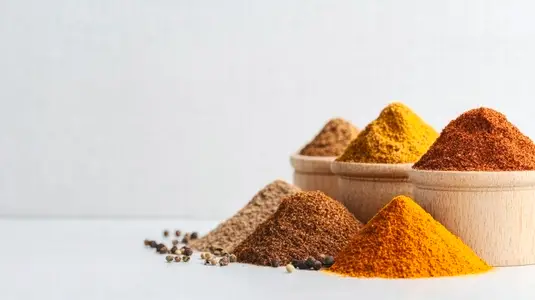 Colorful spices in small piles on white surface