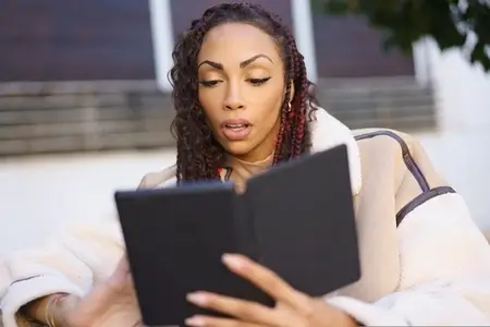 An Engaged Reader Is Enjoying Their Digital Book While Relaxing Outdoors in Natures Beauty