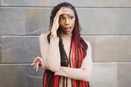 A Stylish Woman with an Uniquely Designed Hairstyle Posing Against a Modern Backdrop