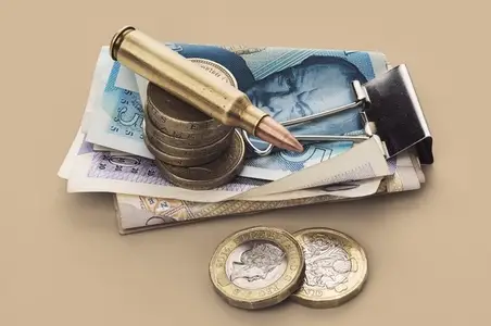 UK Defense Spending still life of bullet cartridge and coins