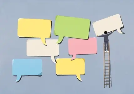 Businessman on ladder arranging large multicolored speech bubbles
