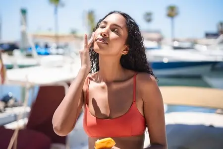 Joyful and Relaxing Summer Vibes A Young Woman Happily Enjoying a Snack by the Water Joyful and Relaxing Summer Vibes A Young Woman Happily Enjoying a Snack by the Water