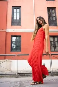 An Elegant Woman in a Stunning Red Dress Posing Beautifully Against a Vibrant Urban Backdrop