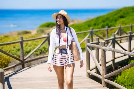 A Young Woman is Enjoying a Beautiful Summer Day by the Beach  Relaxing and Smiling