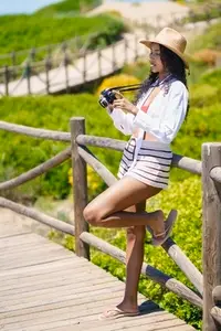 Summer Vibes A Joyful Woman in Colorful Beachwear Capturing the Beauty of Nature with her Camera
