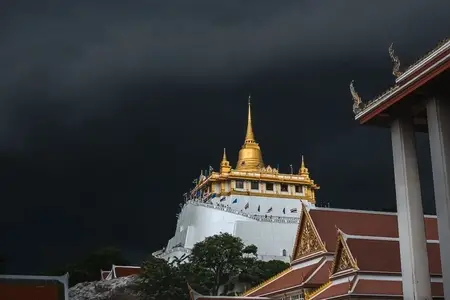 Golden mountain in Wat Saket Bangkok Thailand covered with dark