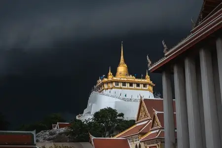Golden mountain in Wat Saket Bangkok Thailand covered with dark