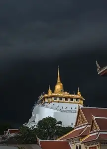Golden mountain in Wat Saket Bangkok Thailand covered with dark