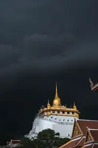 Golden mountain in Wat Saket Bangkok Thailand covered with dark