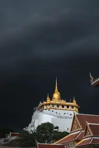 Golden mountain in Wat Saket Bangkok Thailand covered with dark