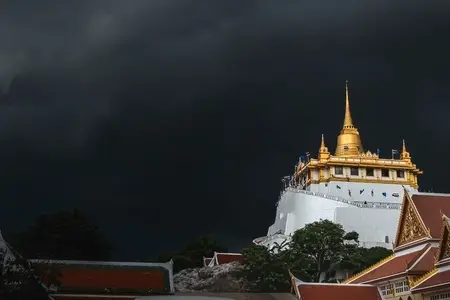 Golden mountain in Wat Saket Bangkok Thailand covered with dark