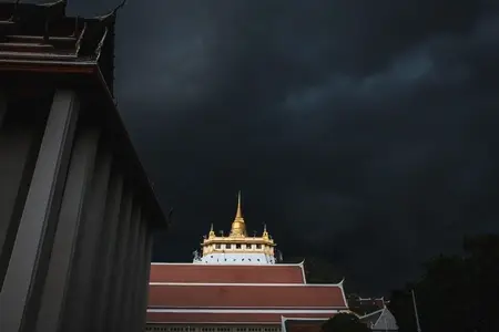 Golden mountain in Wat Saket Bangkok Thailand covered with dark