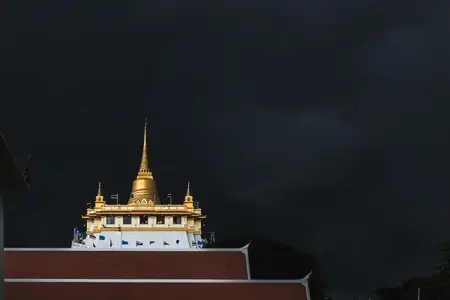 Golden mountain in Wat Saket Bangkok Thailand covered with dark