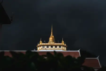 Golden mountain in Wat Saket Bangkok Thailand covered with dark