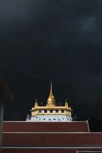 Golden mountain in Wat Saket Bangkok Thailand covered with dark