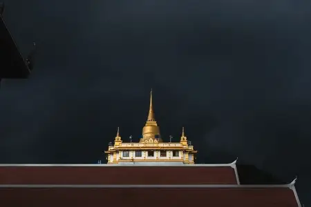 Golden mountain in Wat Saket Bangkok Thailand covered with dark