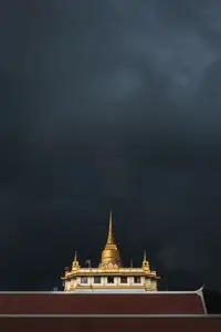 Golden mountain in Wat Saket Bangkok Thailand covered with dark