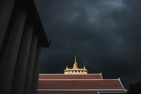 Golden mountain in Wat Saket Bangkok Thailand covered with dark