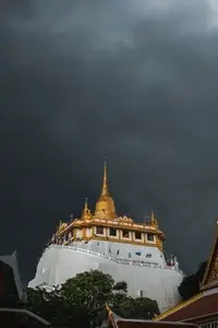 Golden mountain in Wat Saket Bangkok Thailand covered with dark