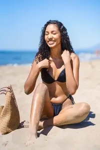A Young Woman is Fully Enjoying a Beautiful Day at the Beach Under Vibrant Sunshine Today