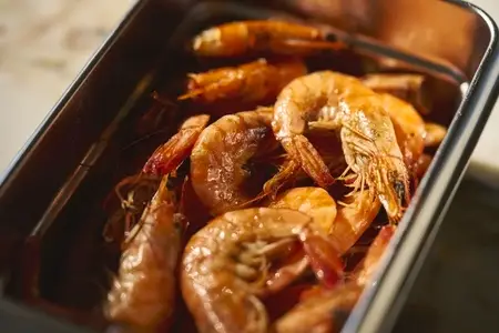 Close up still life shot of cooked prawns in stainless steel container