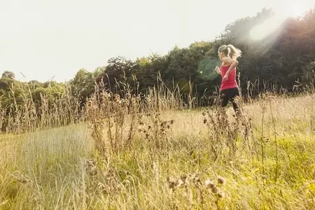 Woman jogging in sunny rural summer field
