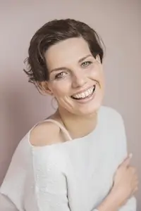 Formal portrait of beautiful happy young woman with short brown hair and blue eyes