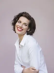 Studio portrait of beautiful brunette woman in red lipstick smiling