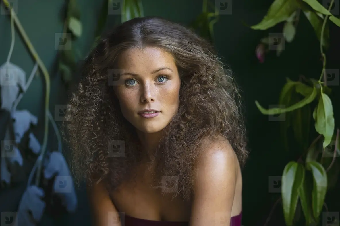 Portrait Of Beautiful Young Woman With Curly Brown Hair And Blue Eyes ...