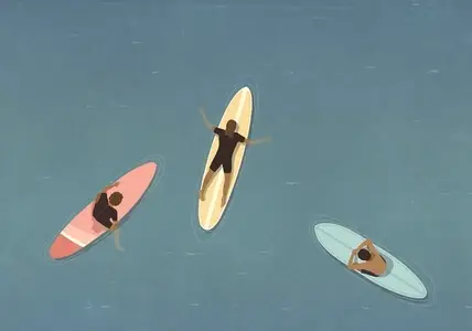 View from above of surfers laying on surfboards in ocean View from above of surfers laying on surfboards in ocean