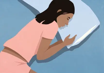 View from above of woman in pink pajamas sleeping on pillow in bed at night