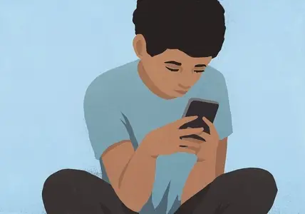 Focused boy using smart phone against blue background