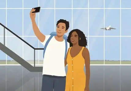 Happy couple on vacation taking selfie with smart phone in airport concourse