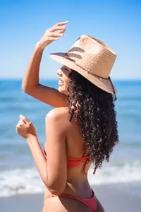 Joyful Beach Day A Woman in a Straw Hat is Happily Enjoying the Sun and the Warm Sea