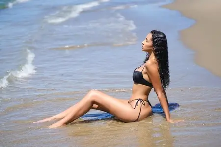 A Relaxing Beach Moment A Model Fully Enjoys the Gentle Waves and the Sunlit Coastline