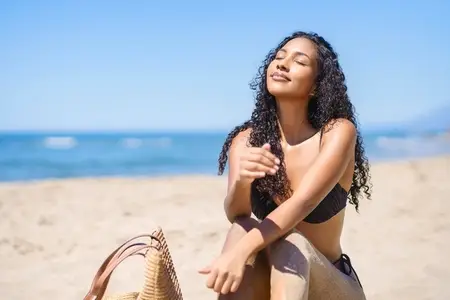 A Young Woman Happily Enjoying a Beautiful Sunny Day at the Beach with Total Bliss