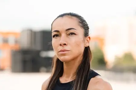 Close up portrait of a young sportswoman with long hair looking at camera