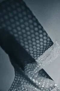 Close up of bubble wrap casting geometric shadows on a surface  Abstract minimal texture in monochrome light