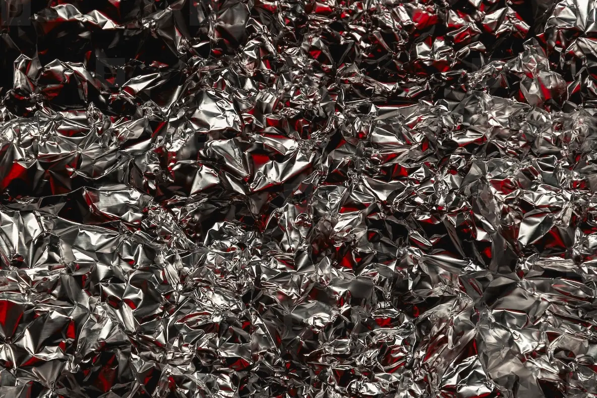 Shiny Crumpled Foil With Silver And Red Reflections Creating A