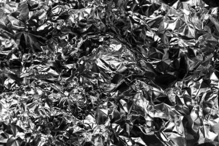 Shiny crumpled foil with metallic abstract look  futuristic texture  chrome surface and cyberpunk style reflective pattern