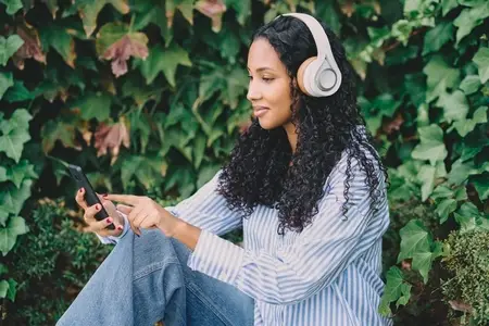 A Young Woman is Enjoying Listening to Music through Headphones while in a Beautiful Natural Setting