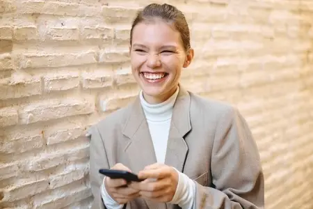 A Cheerful and Engaging Businesswoman Interacting with Her Smartphone in a Modern Urban Setting