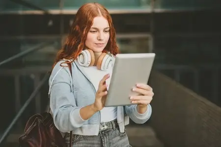 A young woman engages with her tablet in a lively city  showcasing a trendy  techsavvy life