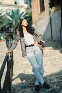 A Fashionable Young Woman is Posing Outdoors in Her Stylish Attire and Accessories