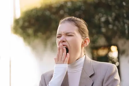 A Yawning Female in Stylish and Contemporary Outerwear Reflects Morning Weariness and Fatigue A Yawning Female in Stylish and Contemporary Outerwear Reflects Morning Weariness and Fatigue