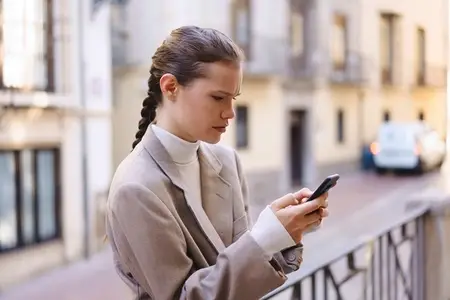 Young woman using her smartphone in a lively urban setting  merging tech with daily life
