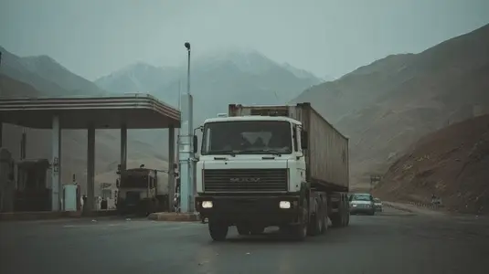 Cargo truck border customs checkpoint mountain road overcast transport