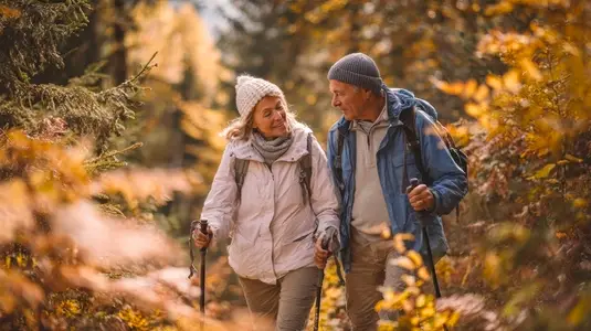 Senior couple hiking autumn forest  smiling  outdoor adventure  nature  active lifestyle
