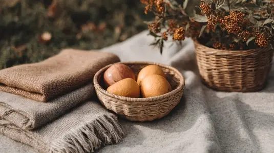 Wicker basket with apples and pears on cozy blanket  autumn picnic in park  warm natural light