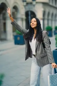 A Stylish and Chic Woman Hailing a Taxi in a Dynamic Urban Setting During the Daytime